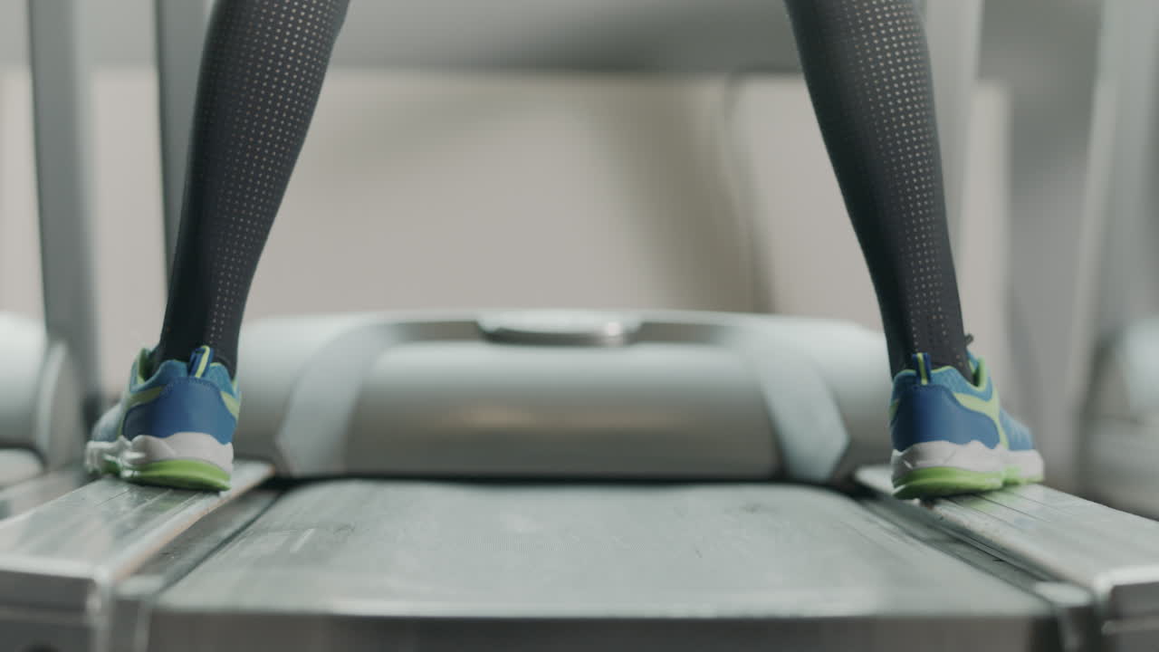 Closeup athletic feet running on running machine in fitness gym.