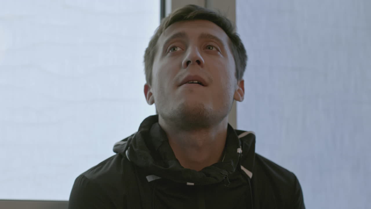 Uomo che guarda in alto alla finestra
