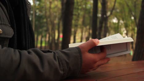 closeup view man reading book in autumn park