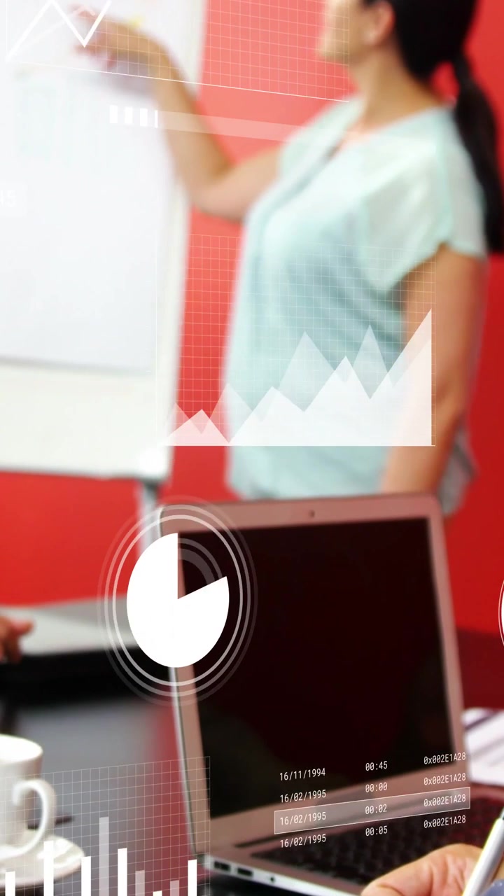 Video verticale: Un responsabile aziendale che indica un grafico, facendo sì che i grafici sul laptop spieghino i dati, con il team che prende appunti.