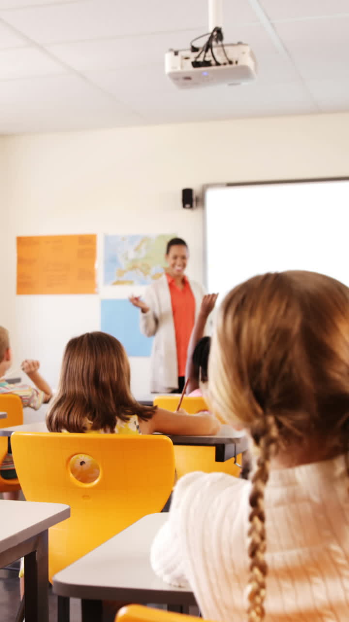 niños de la escuela levantando la mano en el aula