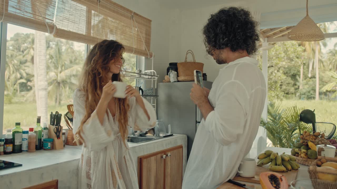Pareja disfrutando café en una cocina tropical