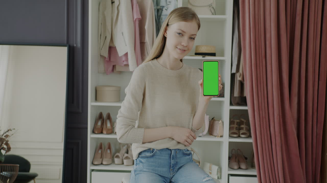 Woman showcasing a mobile phone in a fashion-themed setting