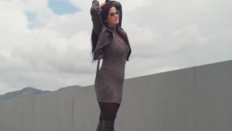 a woman is having fun on a rooftop with the skyline of port of spain, trinidad, behind her