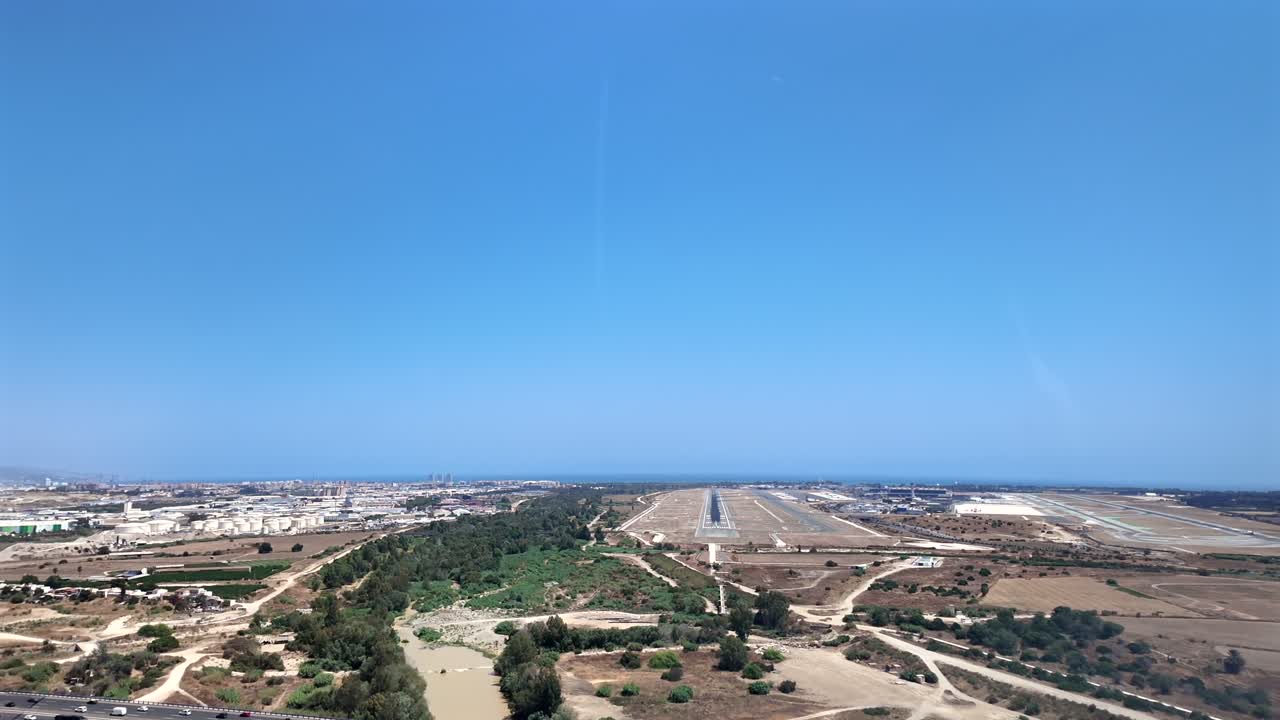 An aerial view taken from a jet cockpit in the final approach to Málaga’s airport, with parallel runways ahead, under a bright blue sky