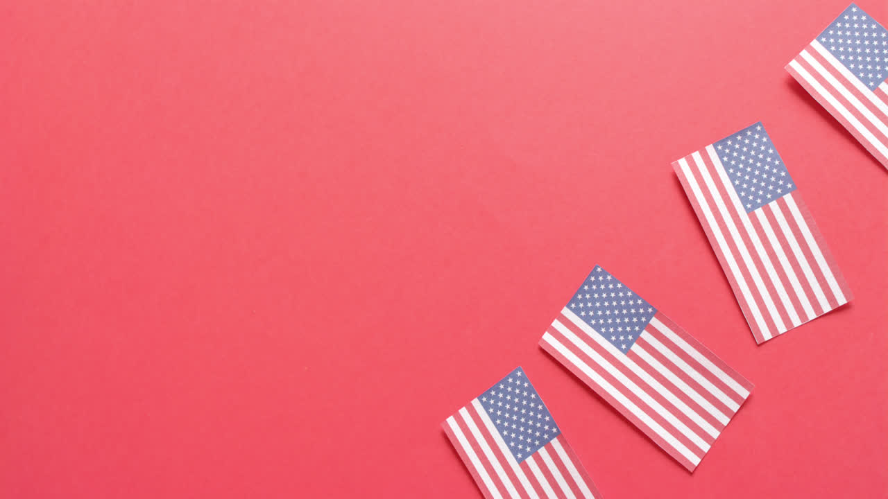 Quattro bandiere nazionali degli USA adagiate su sfondo rosso con spazio per il testo