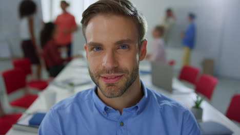 handsome man looking camera modern office. businessman posing in meeting room