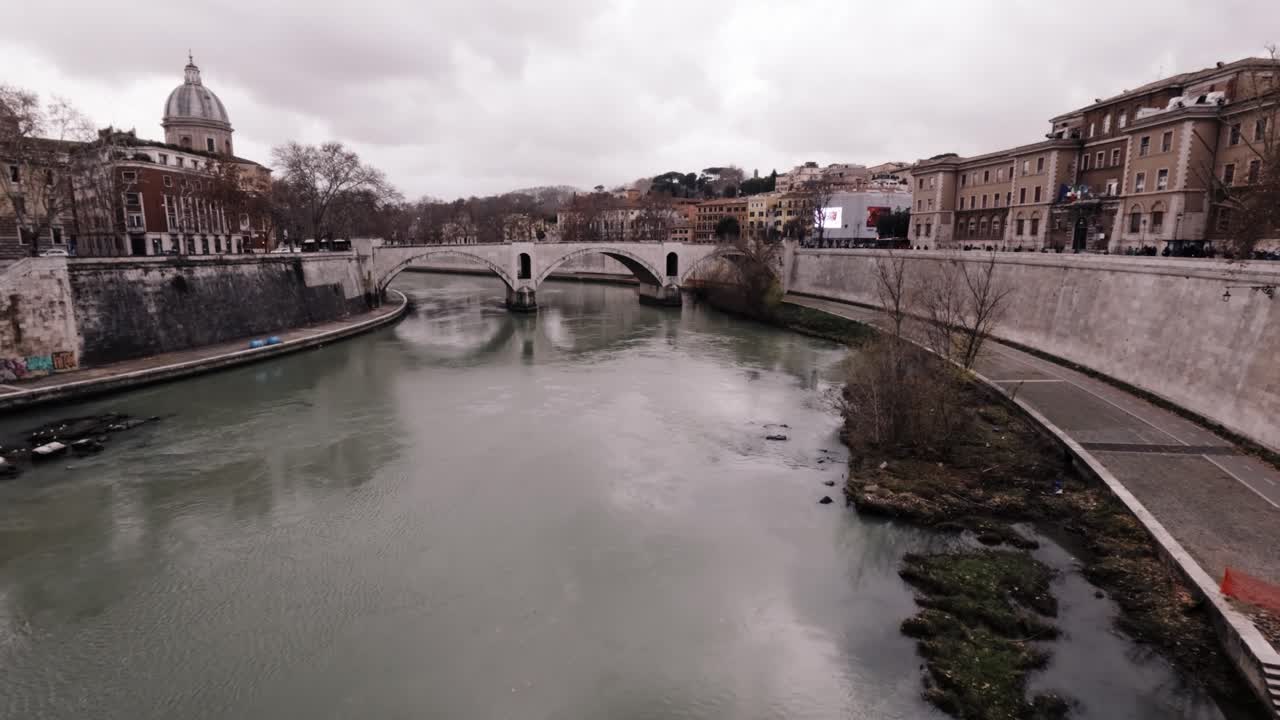 Serene views of the Tiber River flowing through urban Rome during a calm winter afternoon