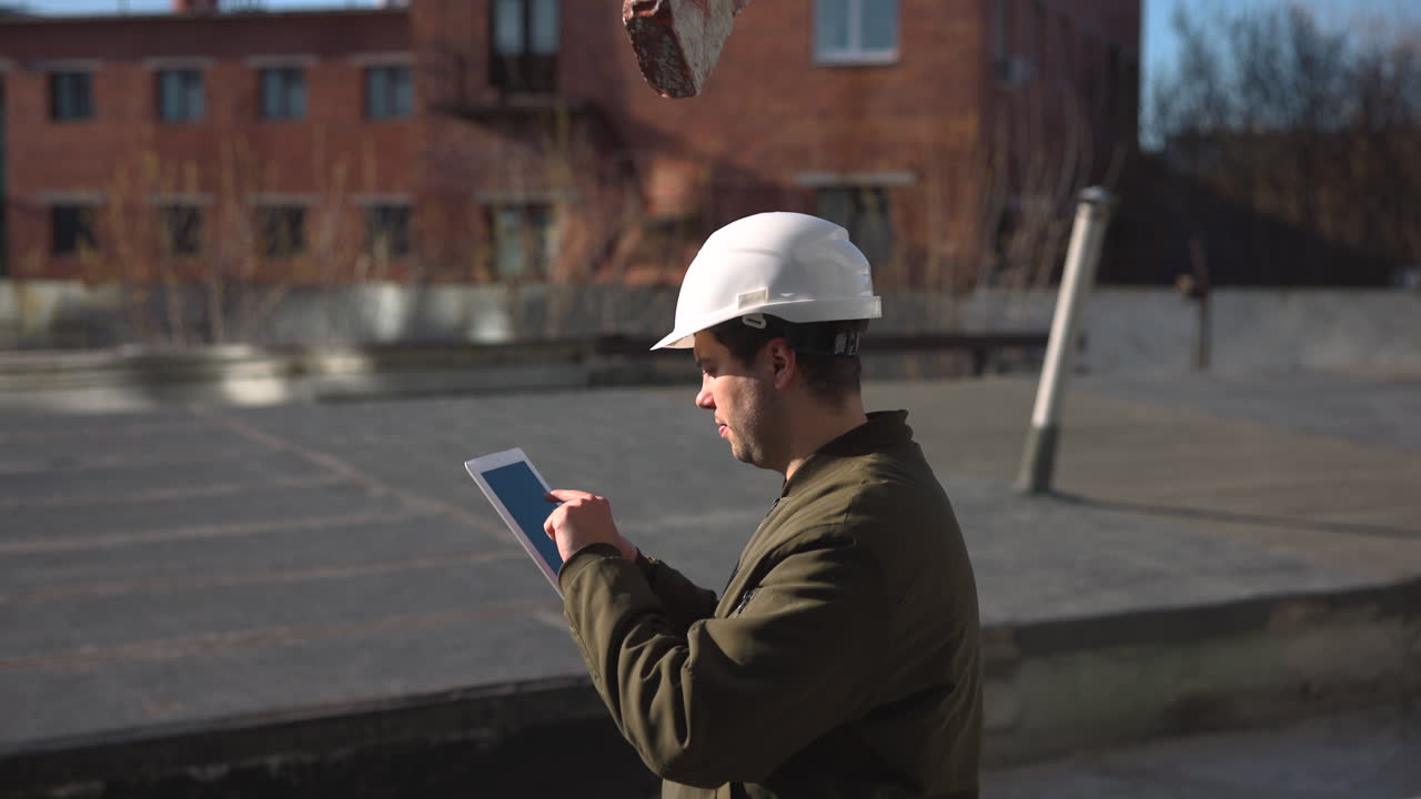 White Construction Inspector Checking Tablet On Rooftop, Urban Industrial Background, Focused Expression