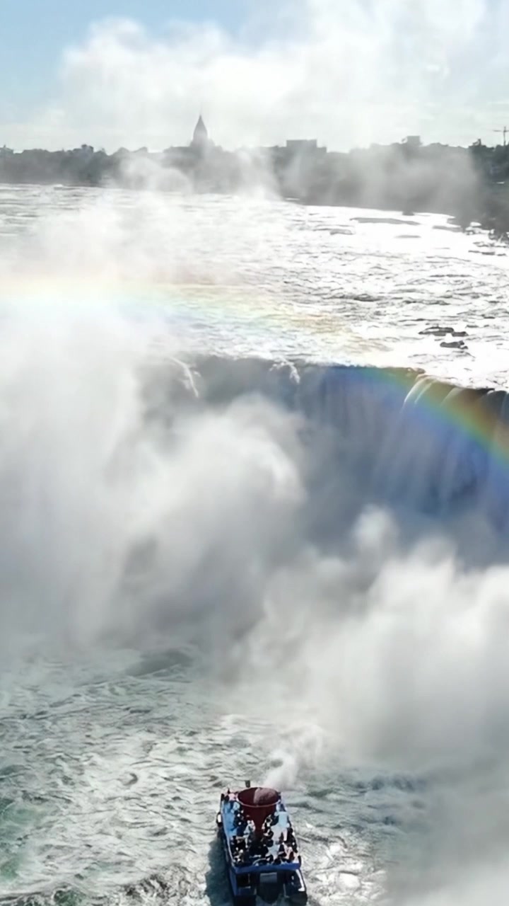 Experience the Majestic Beauty of the Waterfall and Rainbow at the River, Captured in Stunning Clarity from the Boat Below, Surrounded by Mist and Natural Wonder