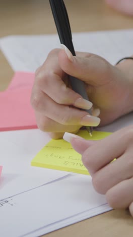 vertical shot of students hands as they work on a group project