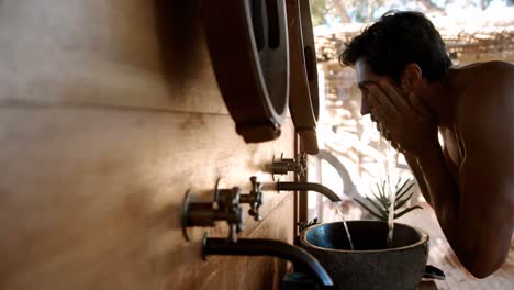 hombre lavando la cara del agua en la cabaña 4k
