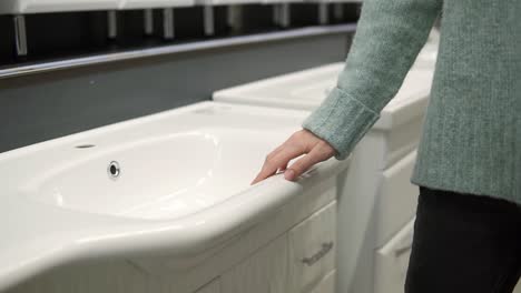 woman is choosing a new ceramic sink in a store