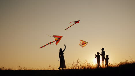 A-Young-Sam-With-Two-Children-Plays-Kites-At-Sunset-In-A-Picturesque-Place-Family-Activity-Outdoors