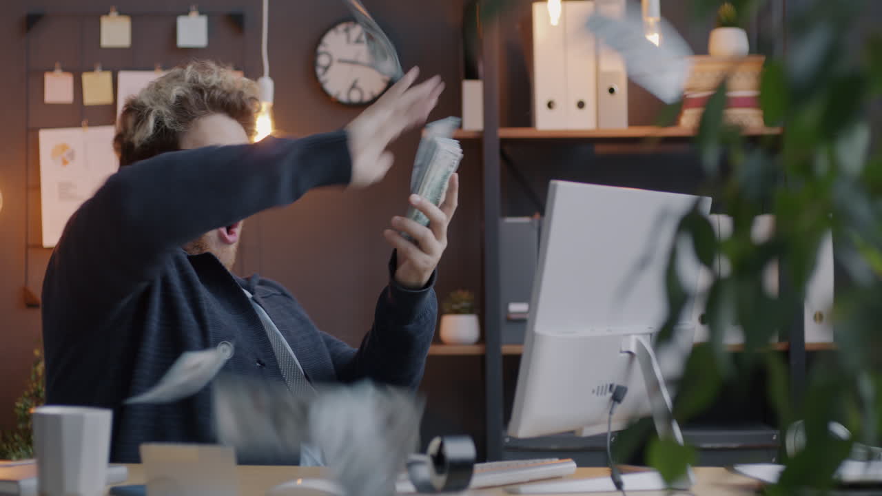 Man Celebrating Success in Office with Money
