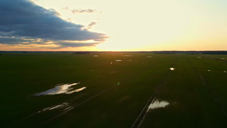 vista panorámica de campos y humedales durante la puesta del sol