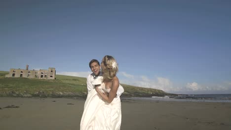 smiling newlyweds running to the camera on the beach