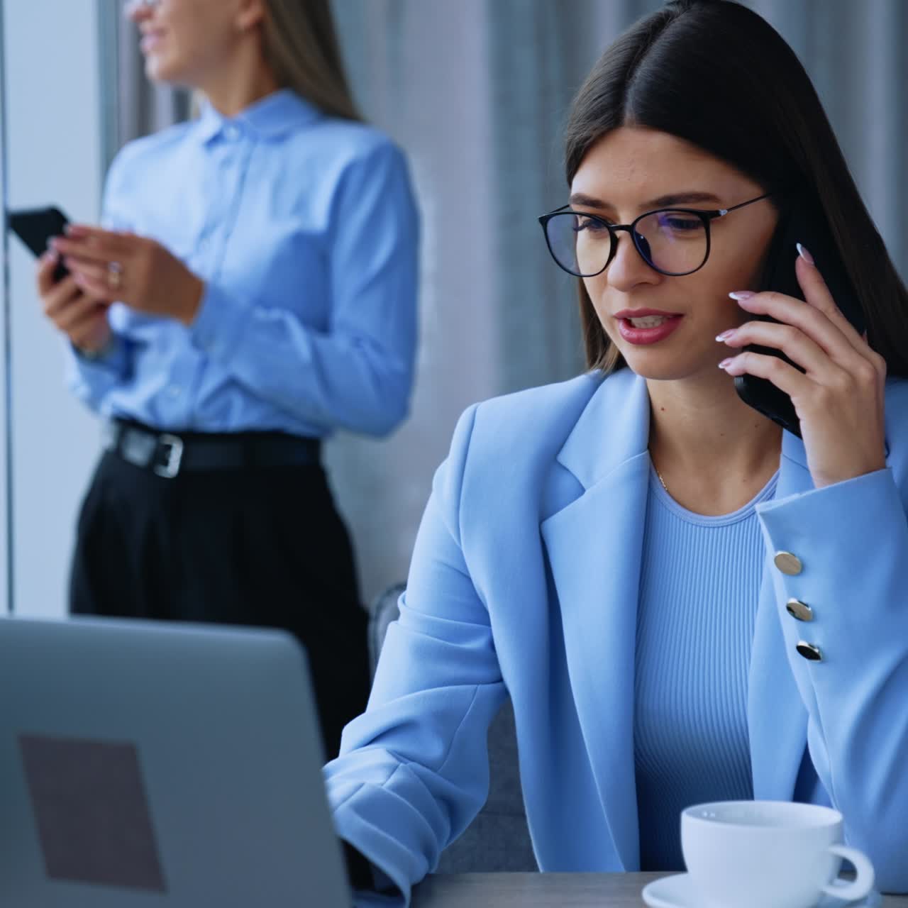 Modern office employees at work. Female workers using modern gadgets. Ladies speaking on the smartphone