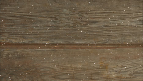 digital composition of snow falling over textured wooden surface