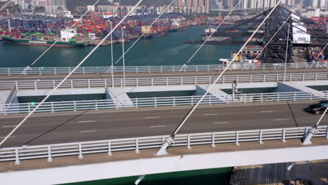 container ships docked at container port behind suspension bridge in hong kong