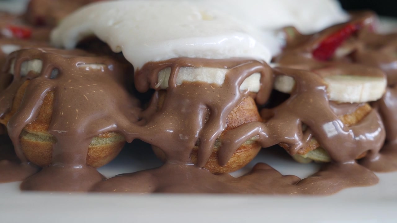 Delizioso bubble waffle guarnito con salsa al cioccolato e panna