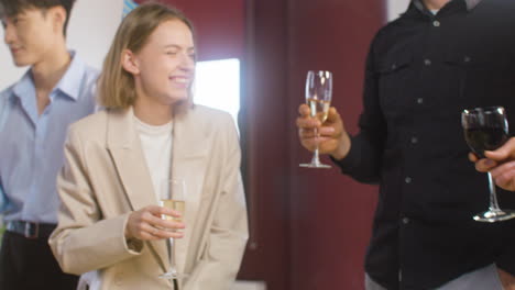 happy multiethnic colleagues toasting with champagne and wine and drinking at the office party 4