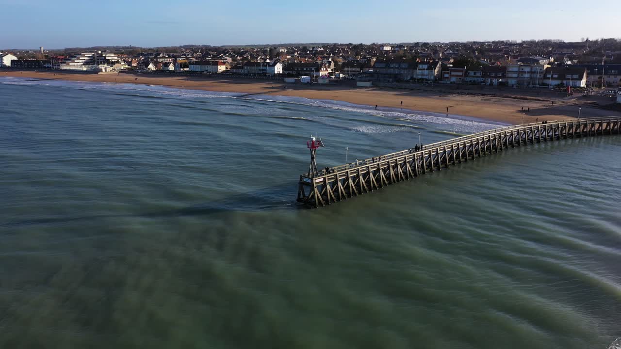 toma de drones del muelle de courseulles-sur-mer en normandía con vistas a la ciudad desde el océano