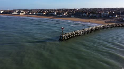 drone-shot-of-the-pier-of-courseulles-sur-mer-in-normandy-with-a-view-on-the-city-from-the-ocean