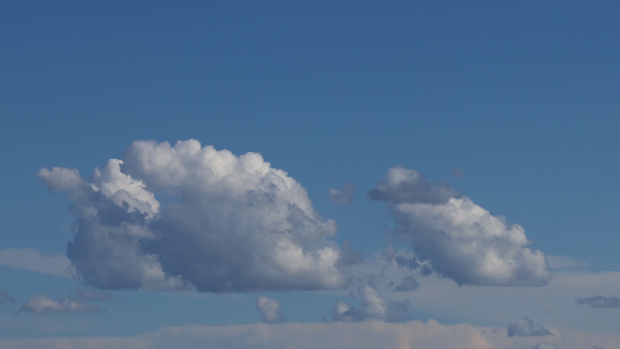 은 파란 하늘을 가로질러 움직이는 큐러스 구름