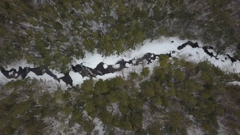 Horizontal-top-down-aerial-shot-of-snowy-river-in-winter