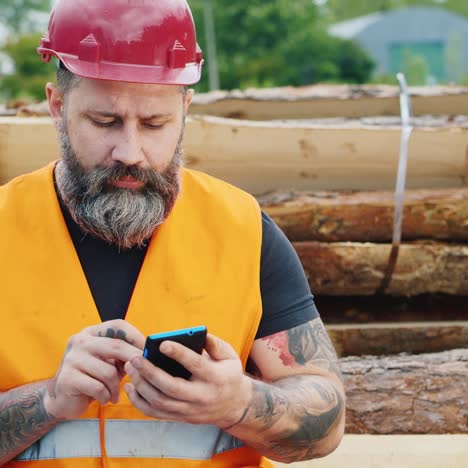 Un-Constructor-Barbudo-Con-Casco-Usa-Un-Teléfono-Inteligente-1