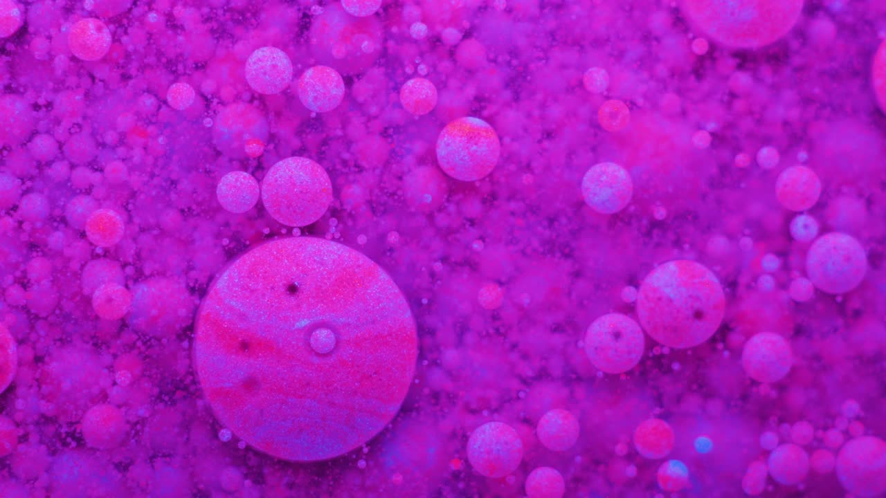 Slow Motion Bright Neon Color Bubbles Oil Beautiful Fluorescent Paint Sparkling Color Moving Multicolor Close up. Acrylic Neon Paint. Fantastic Surface. Abstract Colorful Transformation Gravitation.