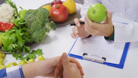 the dietitian doctor tells her patient about healthy eating with a vegetable diet.