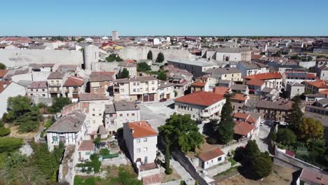 aerial view medieval wall between traditional houses trees blue sky and daylight