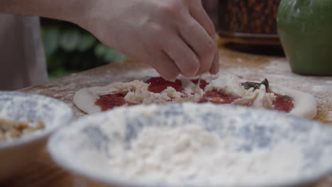 chef puts topping onto the pizza dough