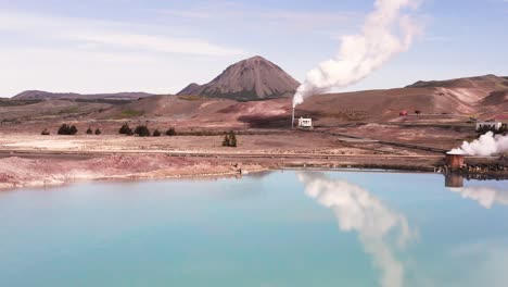 blue lake in iceland at bjarnarflag geothermal power station creating steam