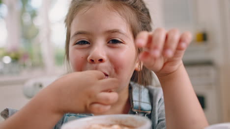 niño pequeño, cara y feliz comiendo el desayuno