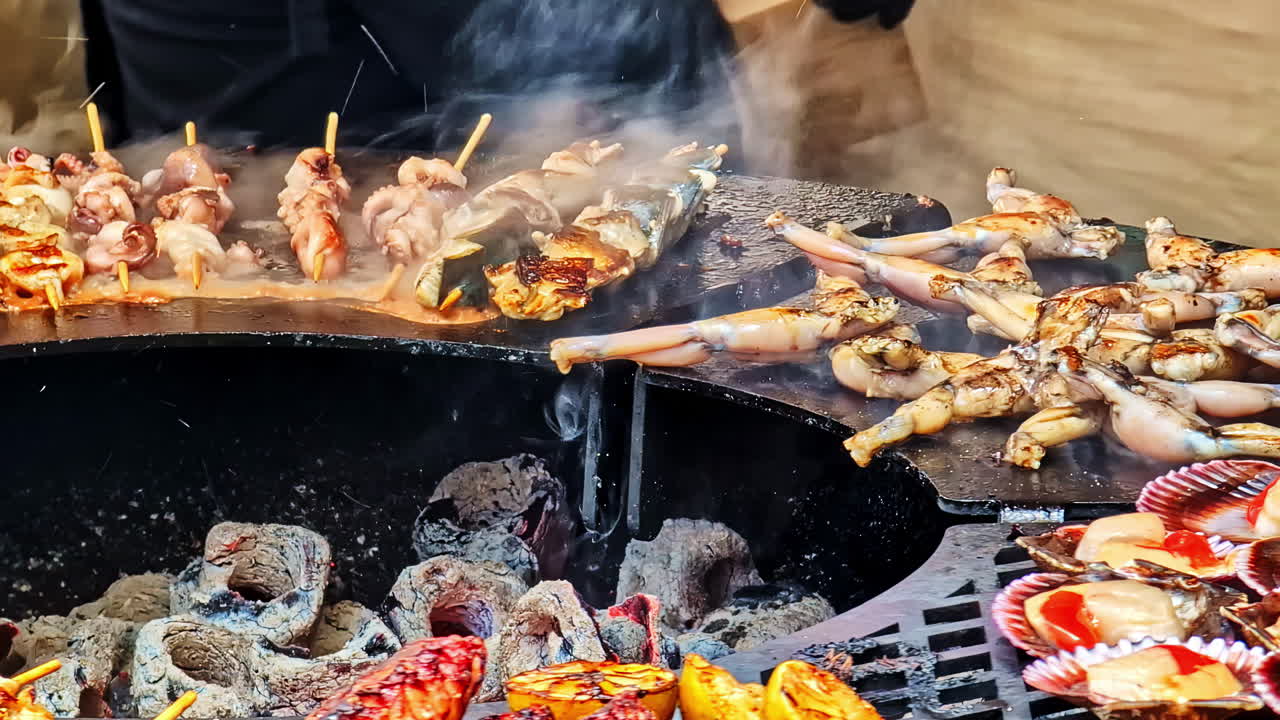 Grilled meats and frog legs on barbecue while tongs flip charcoal