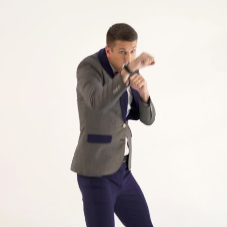 a man in a suit skillfully is copying the movements of a boxer during a fight in the studio. parody from actor