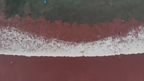 vertical view of surf rolling in on beach in mexico