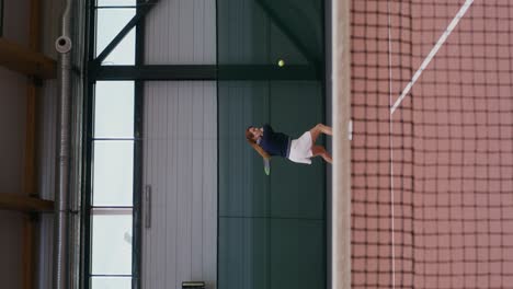 woman playing tennis indoors