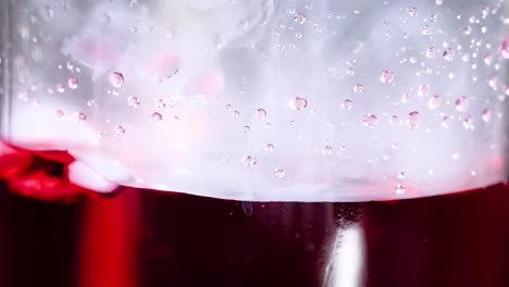 hielo seco reaccionando en un líquido rojo