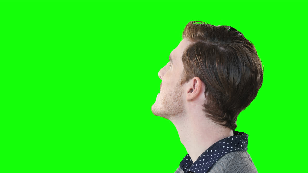 Caucasian man looking up on green background