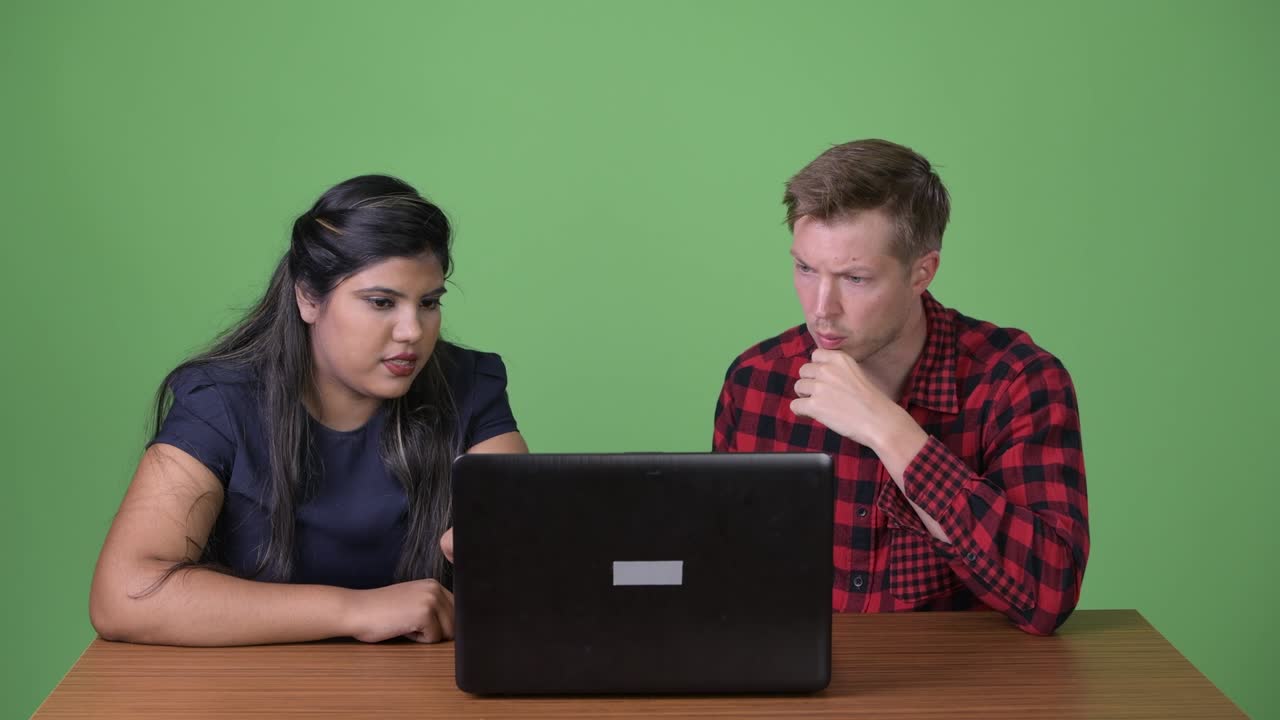 joven pareja de negocios multiétnica juntos contra un fondo verde