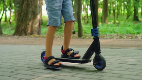 a boy rides a scooter in a city park 01