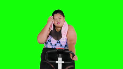 Overweight woman doing workout on exercise bike