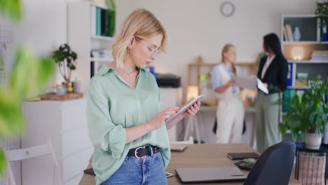 Zuversichtlich-Geschäftsfrau-Arbeitet-An-Digitalen-Tablet-Im-Büro