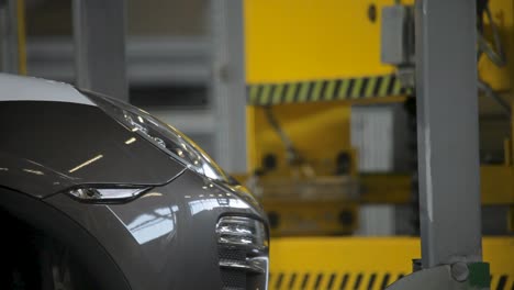 Close-up-of-a-sleek-car-in-a-modern-automotive-factory,-emphasizing-the-shiny-detail-and-industrial-setting