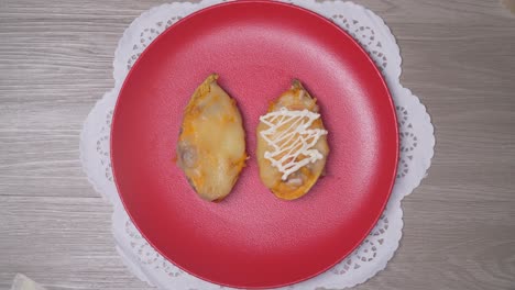 Garnishing-baked-sweet-potatoes-on-red-plate-for-elegant-Christmas-dinner