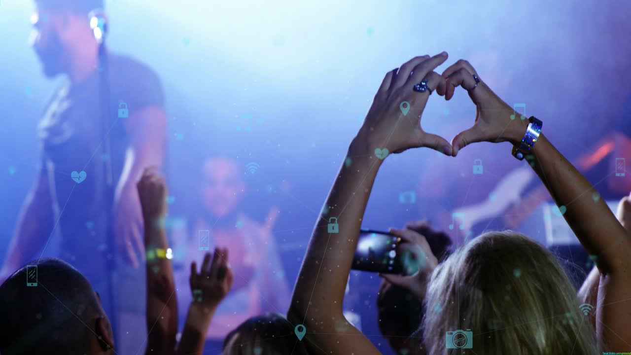 Animation af ikoner, der viser forbindelser, over hænderne på mangfoldige mennesker til koncert